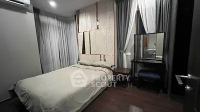 Cozy bedroom with elegant decor and natural light, featuring a comfortable bed and stylish vanity area.