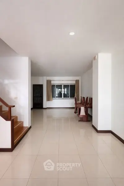 Spacious open-plan living area with elegant staircase and dining space