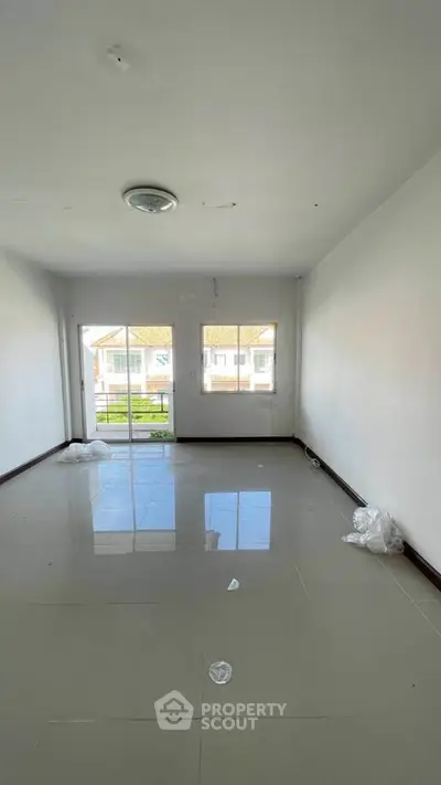 Spacious empty room with large windows and glossy tiled floor, perfect for customization.
