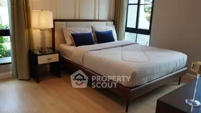 Elegant bedroom with modern decor and large windows offering natural light.