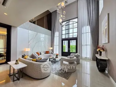 Luxurious high-ceiling living room with elegant decor and large windows