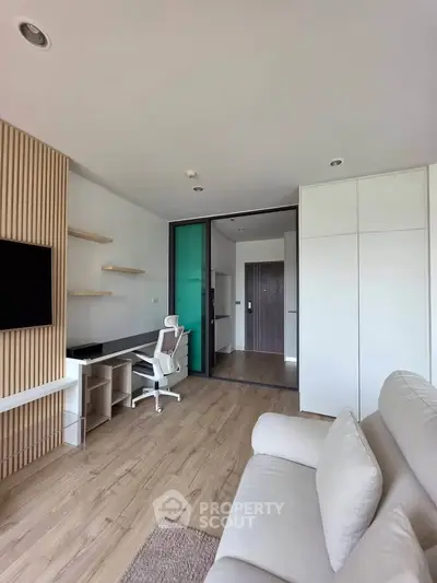 Modern living room with sleek design, featuring a cozy sofa, stylish shelving, and a contemporary workspace.