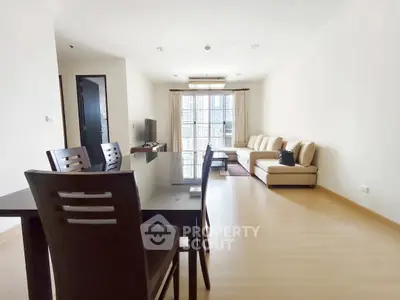 Spacious modern living room with elegant furniture and large windows offering ample natural light.