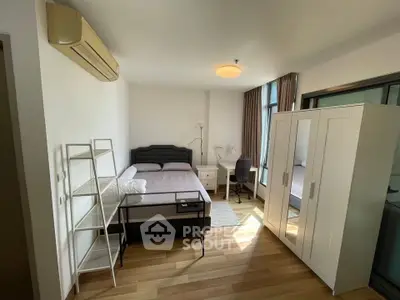 Spacious bedroom with modern furnishings and ample natural light in a stylish apartment.