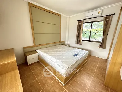 Spacious bedroom with natural light and modern furnishings