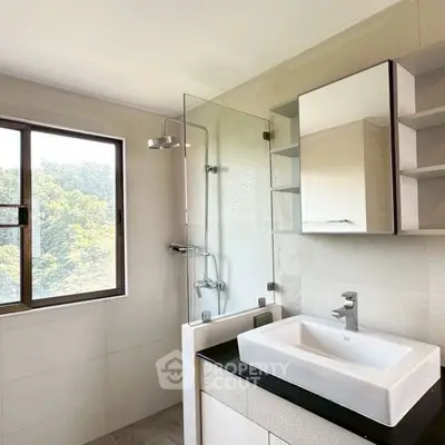 Modern bathroom with sleek fixtures and large window offering natural light.