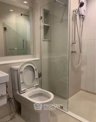 Modern bathroom with glass shower and sleek fixtures in a contemporary apartment.