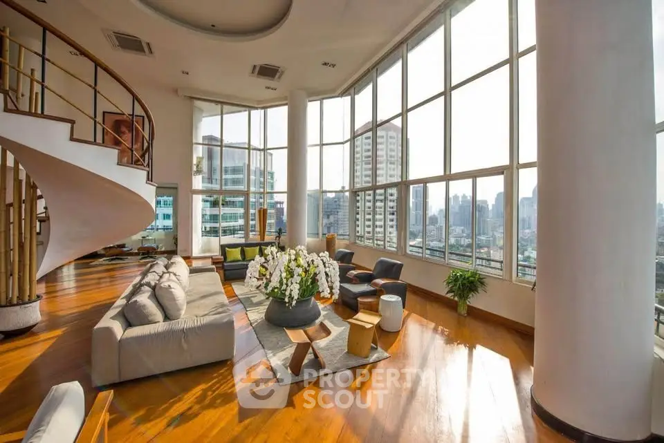 Luxurious penthouse living room with panoramic city views and elegant spiral staircase.