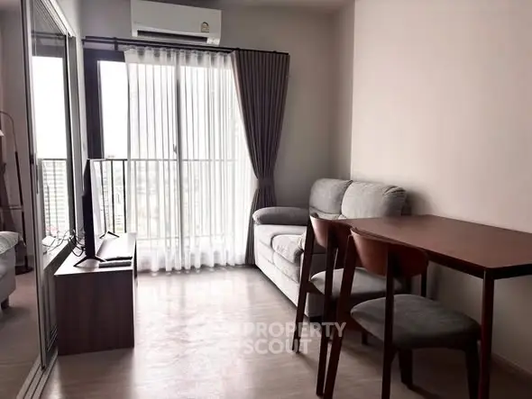 Modern living room with balcony view, featuring cozy seating and dining area.