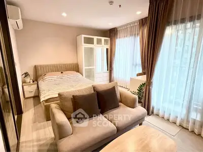 Spacious bedroom with cozy seating area and large windows for natural light.
