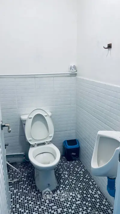 Compact bathroom with white tiles and modern fixtures, ideal for efficient space utilization.