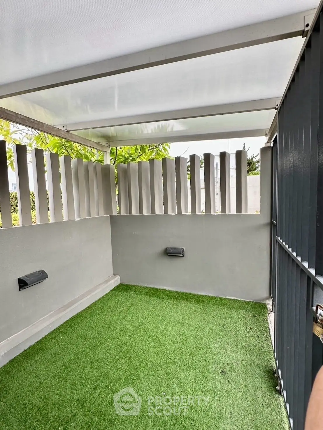Modern outdoor space with artificial grass and sleek fencing, perfect for relaxation.