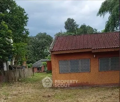 Charming rustic house with red-tiled roof and lush greenery, perfect for serene living.
