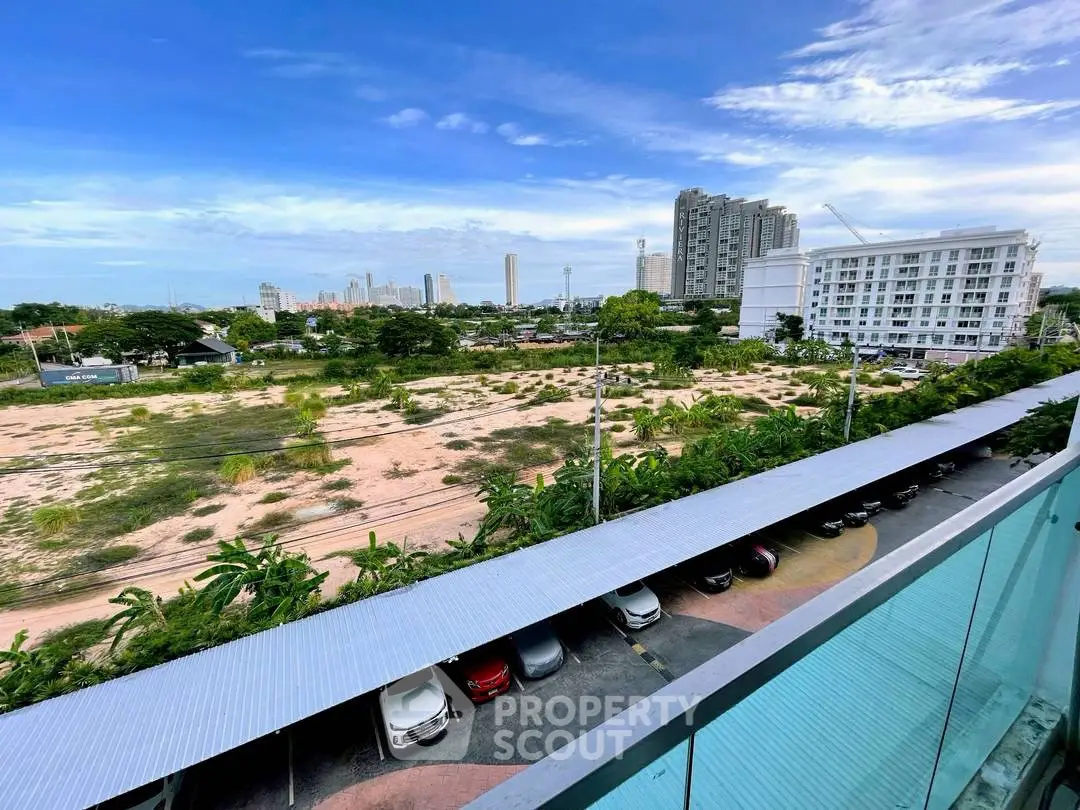 Stunning cityscape view from a modern balcony overlooking urban skyline and greenery.