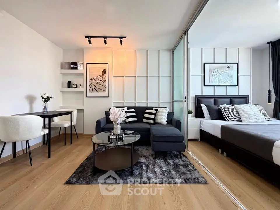 Modern studio apartment with stylish living area and cozy bedroom, featuring elegant decor and natural light.