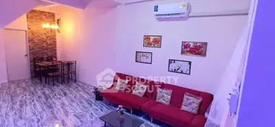 Charming living room with vibrant red sofa and elegant dining area, perfect for cozy gatherings.