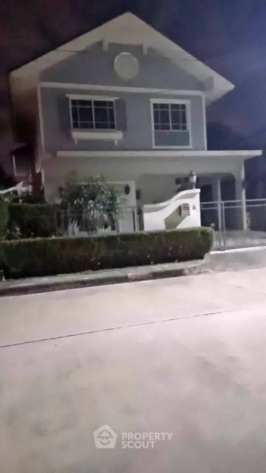 Charming two-story house with a front garden and gated entrance, perfect for family living.