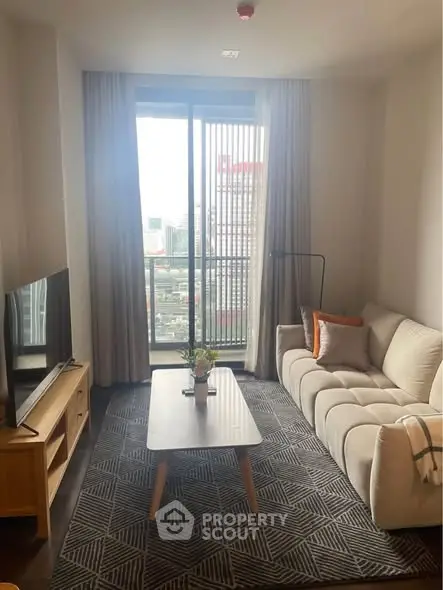 Cozy living room with modern decor and city view from large window.