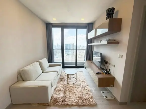 Modern living room with city view, featuring sleek furniture and stylish decor.