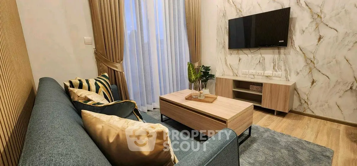 Modern living room with stylish decor, wall-mounted TV, and elegant curtains.