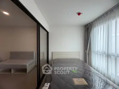 Modern bedroom with large windows and stylish decor in a contemporary apartment.