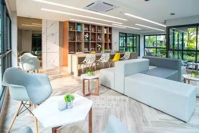 Modern living room with stylish furniture and large windows offering garden views.