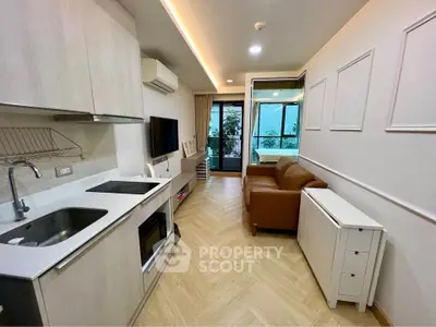 Modern living room with open kitchen and balcony access in stylish apartment.