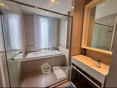 Modern bathroom with glass shower and bathtub in luxury apartment