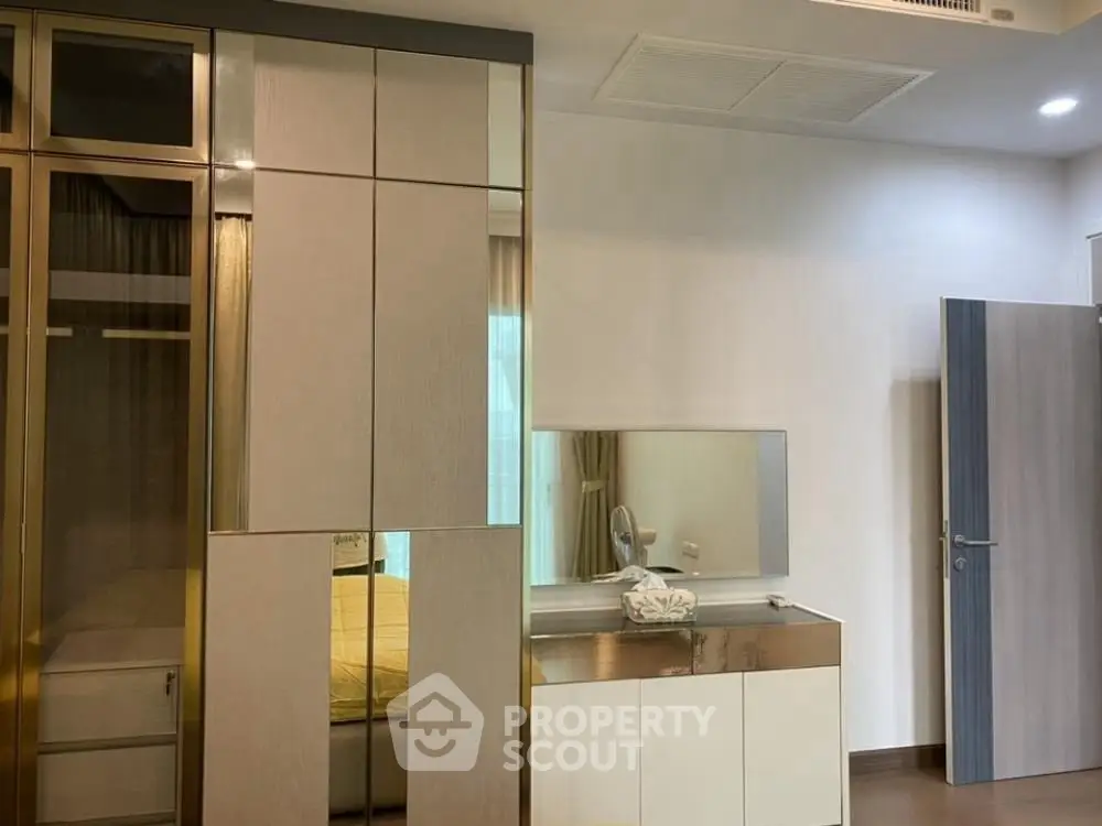 Modern bedroom with sleek wardrobe and vanity mirror