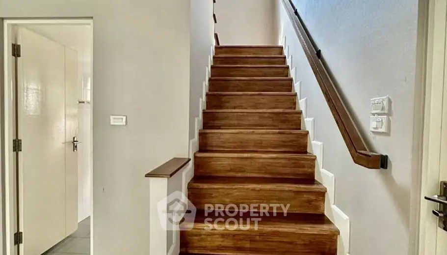 Elegant wooden staircase in modern home interior with white walls