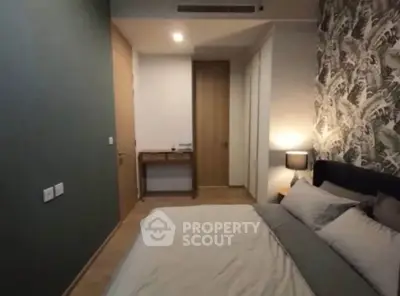 Cozy bedroom with stylish wallpaper and modern decor in a contemporary apartment.