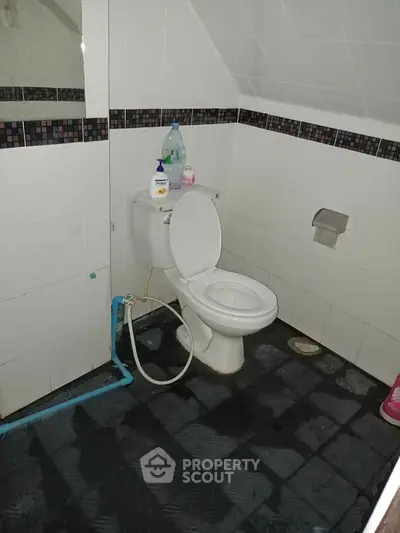 Compact bathroom with white tiles and modern fixtures, ideal for efficient space utilization.