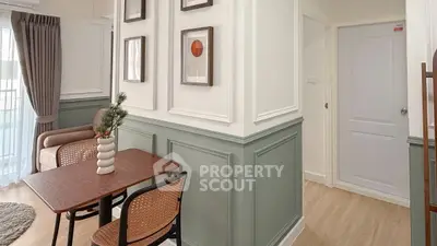 Charming living room with elegant decor and natural light, featuring stylish furniture and wall art.