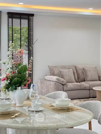 Elegant living room with plush sofa and stylish dining area, perfect for modern living.