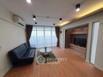 Spacious modern living room with sleek furniture and large windows offering natural light.