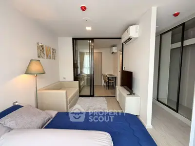 Modern studio apartment with cozy living area and sleek glass partitions.