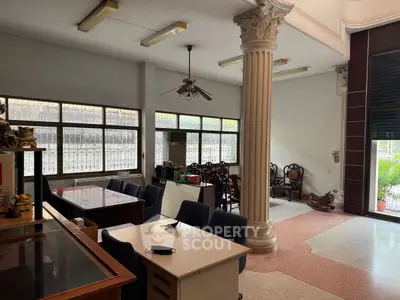Spacious interior with classic columns and large windows, ideal for versatile use.
