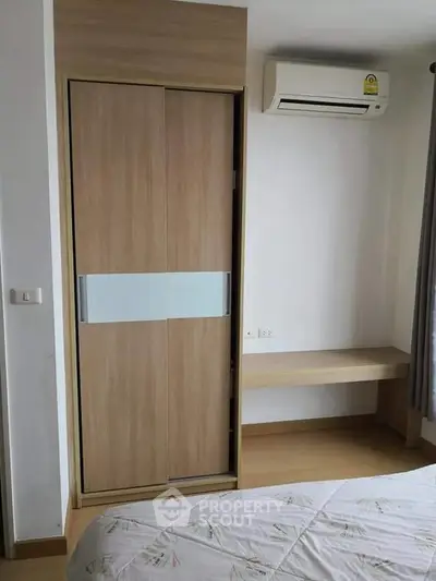 Modern bedroom with built-in wardrobe and air conditioning unit, perfect for comfortable living.