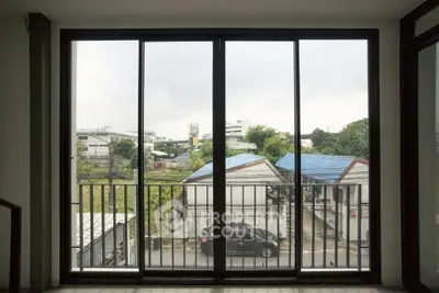 Spacious balcony with sliding glass doors offering urban views