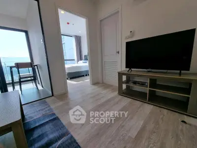 Modern apartment interior with living room, bedroom, and balcony view, featuring sleek wooden flooring and contemporary furniture.