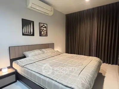 Modern bedroom with stylish decor and air conditioning, featuring a comfortable double bed and elegant curtains.