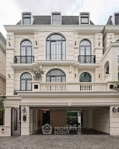 Elegant three-story building with classic architecture and gated entrance.