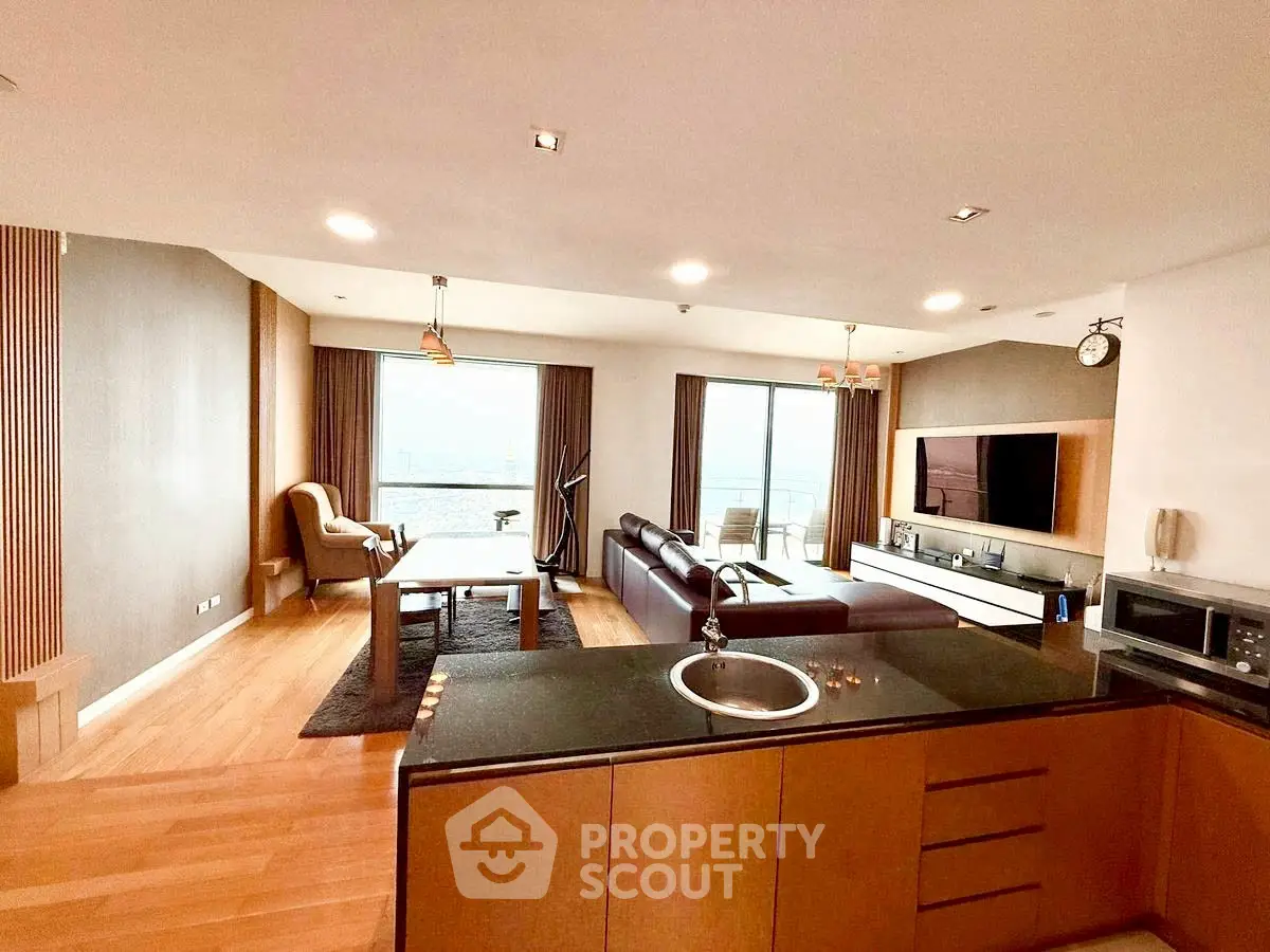 Spacious open-layout living room with modern kitchen and stunning view.