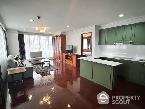 Spacious open-plan living area with gleaming hardwood floors, modern kitchen with ample cabinetry, and a cozy lounge space bathed in natural light.