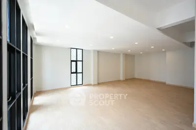 Spacious modern living room with large windows and wooden flooring
