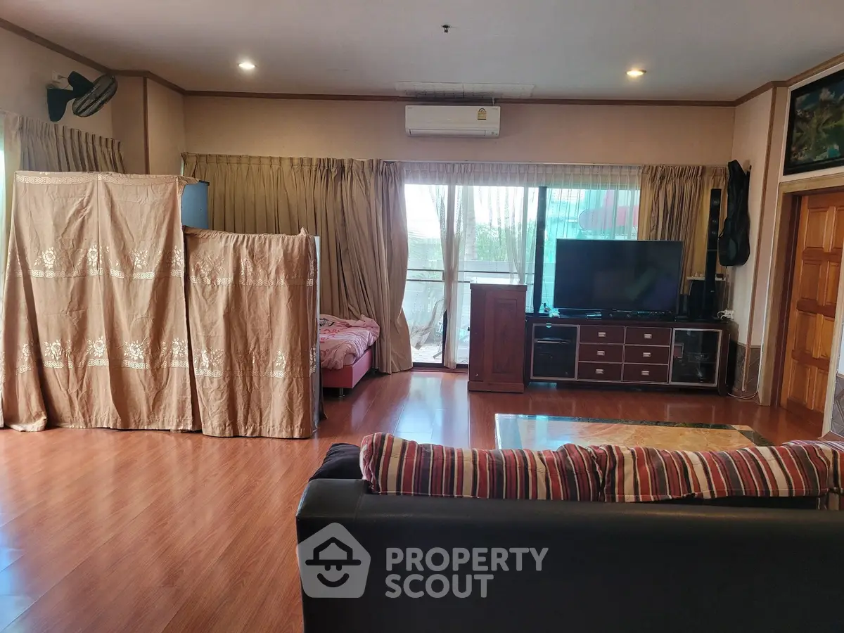 Spacious living room with wooden flooring and large windows for natural light