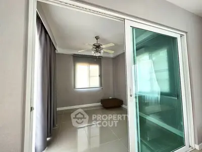 Spacious room with sliding glass doors and ceiling fan, perfect for versatile use.