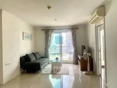 Bright living room with modern decor and city view from balcony.