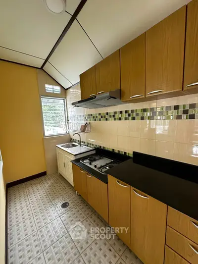 Charming kitchen with gas stove and modern cabinetry in cozy apartment