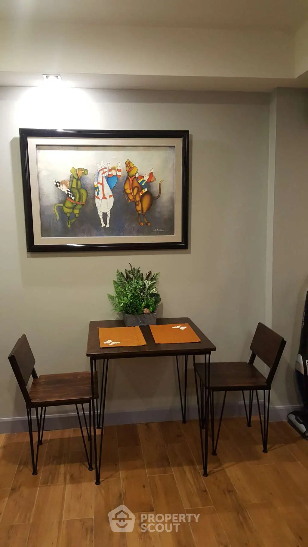 Cozy dining nook with modern table and chairs, featuring stylish wall art and wooden flooring.
